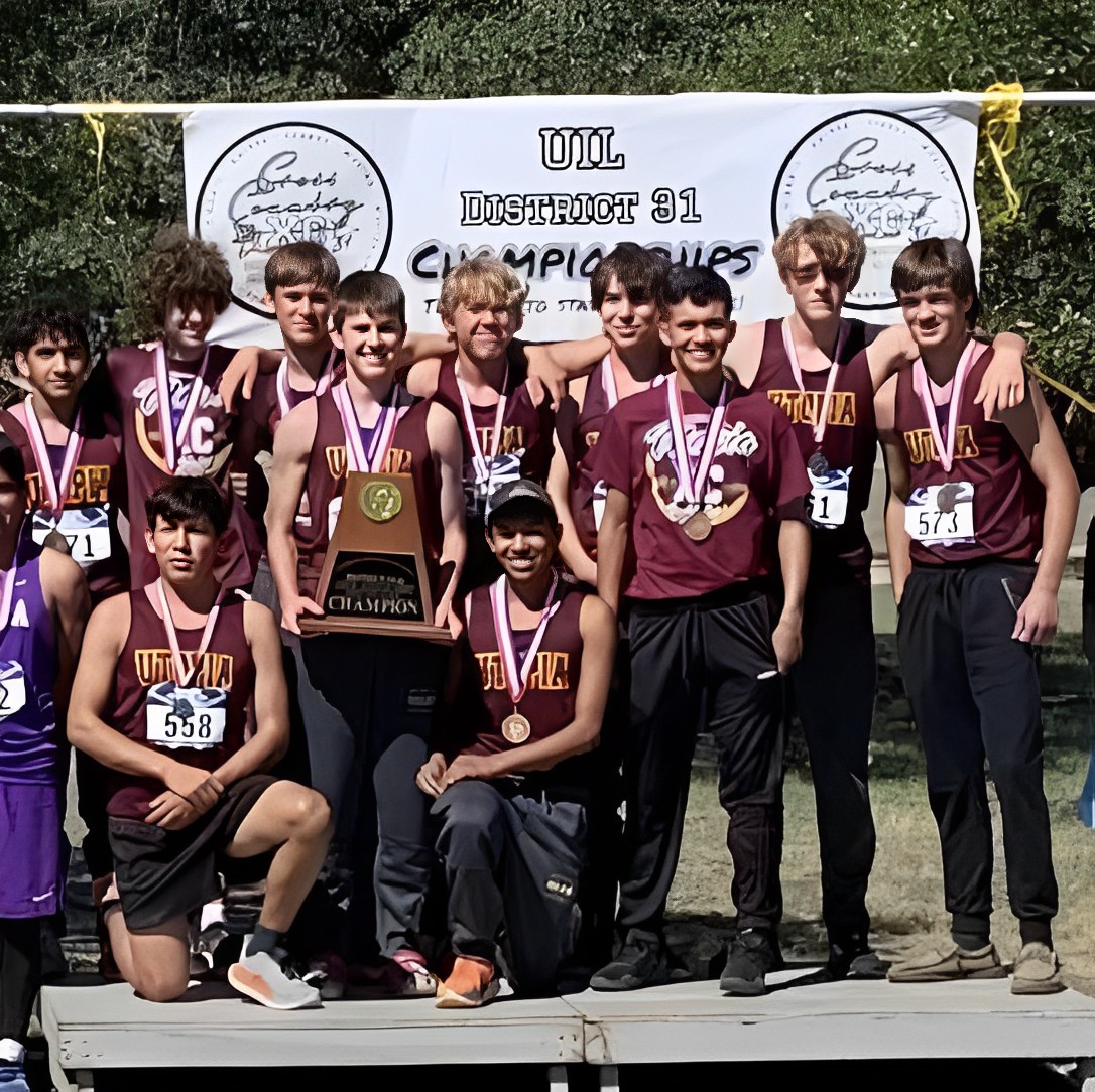 The Utopia Boys Cross Country team showing off their first-place district trophy and individual medals
