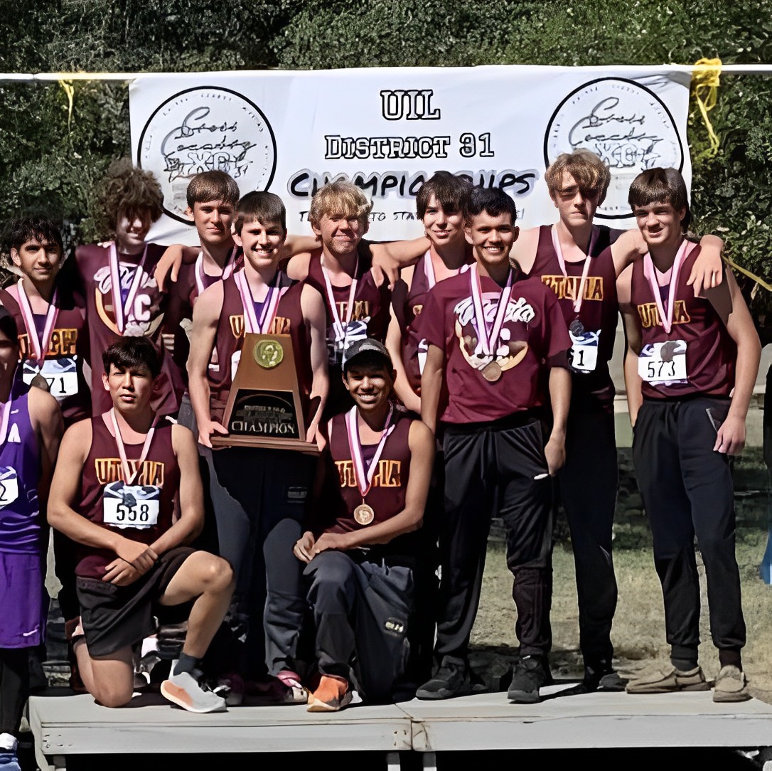 The Utopia Boy's Cross Country team showing off their first-place district trophy and individual medals