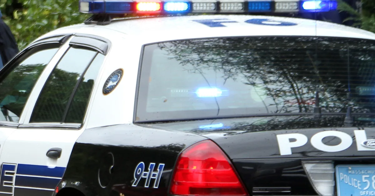 Police and emergency responders at a nighttime crash scene on a closed roadway